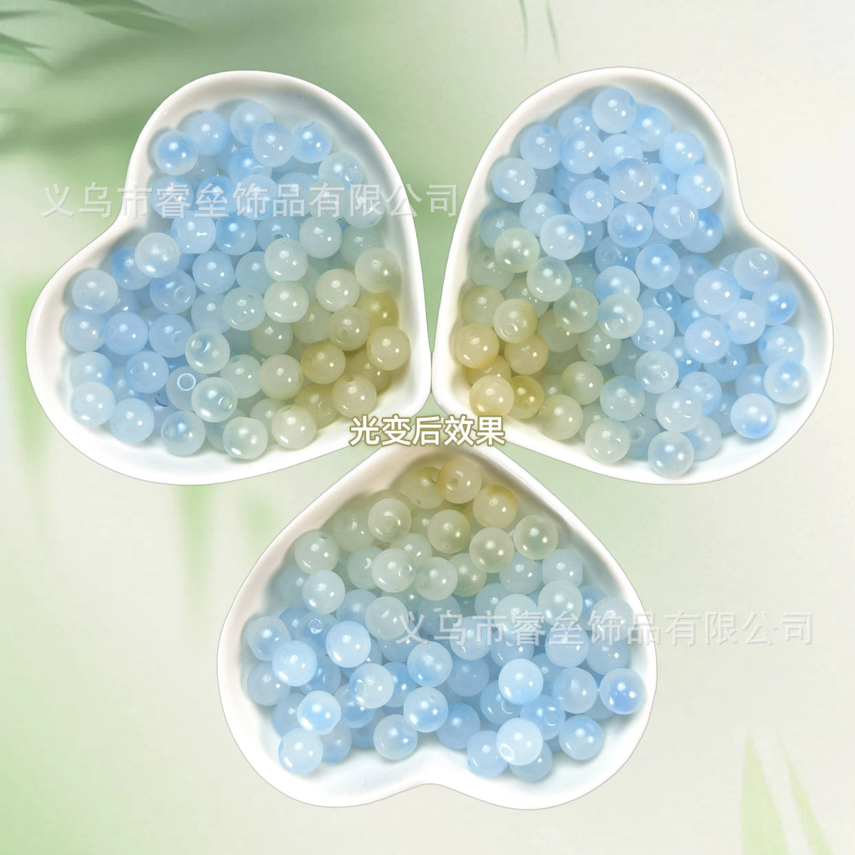Three heart-shaped bowls of pale blue and soft green translucent beads on light green