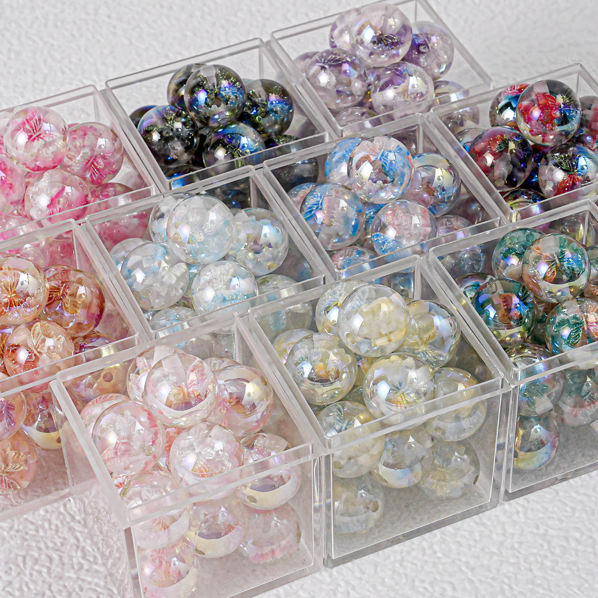 Colorful round butterfly beads in clear plastic compartment boxes on white