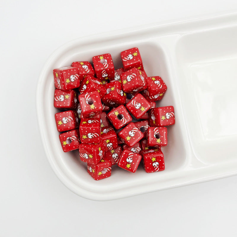 Red square beads with Santa faces, stars and polka dots in a white divided tray