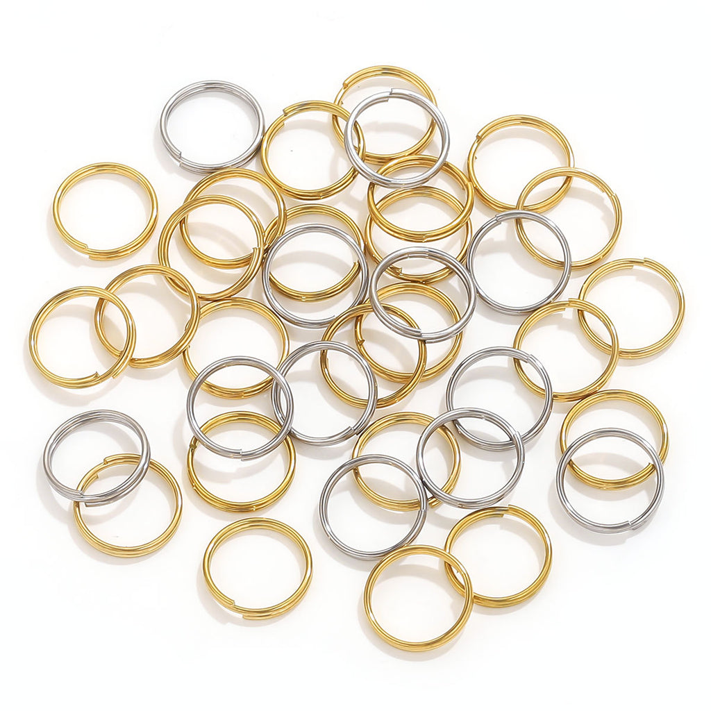 Gold and silver mini split ring connectors piled on white background