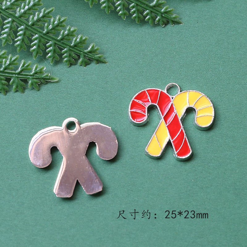 Two candy cane-shaped charms on green background, silver and red-yellow striped