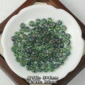 Green iridescent Picasso-finish glass abacus beads with glittery finish in a white scalloped dish on wooden tray.