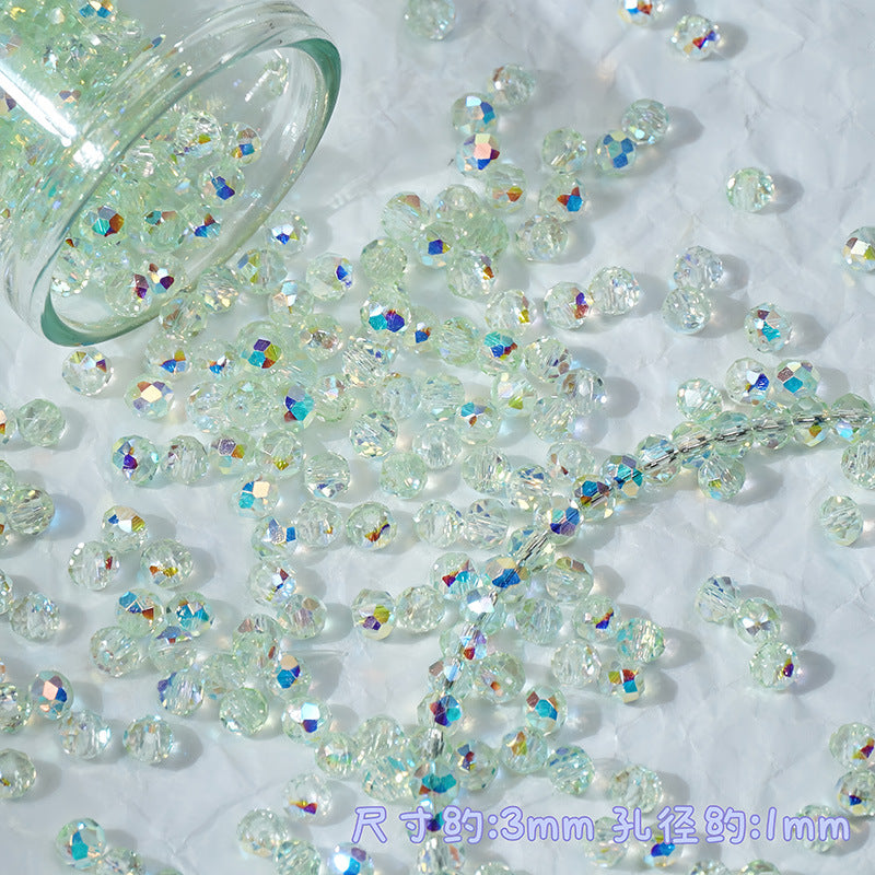 Clear faceted glass beads with an iridescent rainbow sheen scattered on a white textured surface, with a glass jar tipped over to release more beads. Chinese text in the bottom right indicates dimensions: 3mm diameter and 11mm circumference.