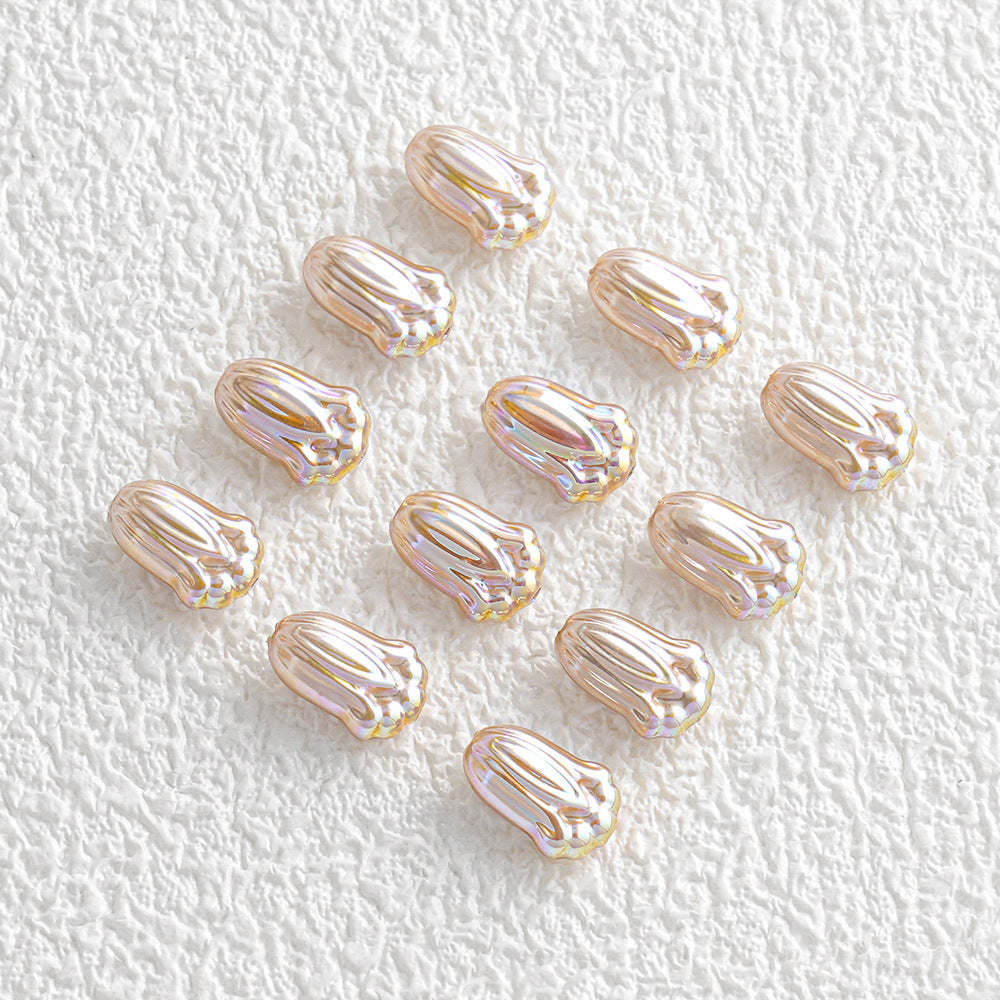 Twelve small iridescent cabochon beads in a loose grid on a textured white background