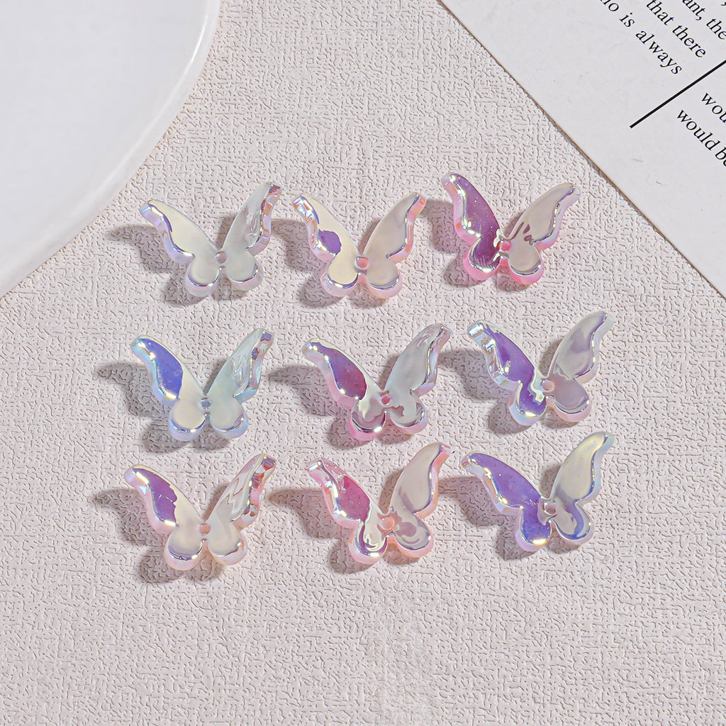 Nine iridescent butterfly acrylic beads in grid showing pastel pink, purple, and blue holographic reflections