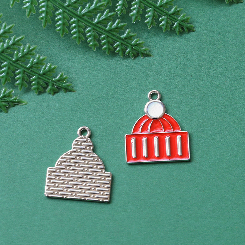 Two small dome-shaped jewelry charms on green background with fern leaves