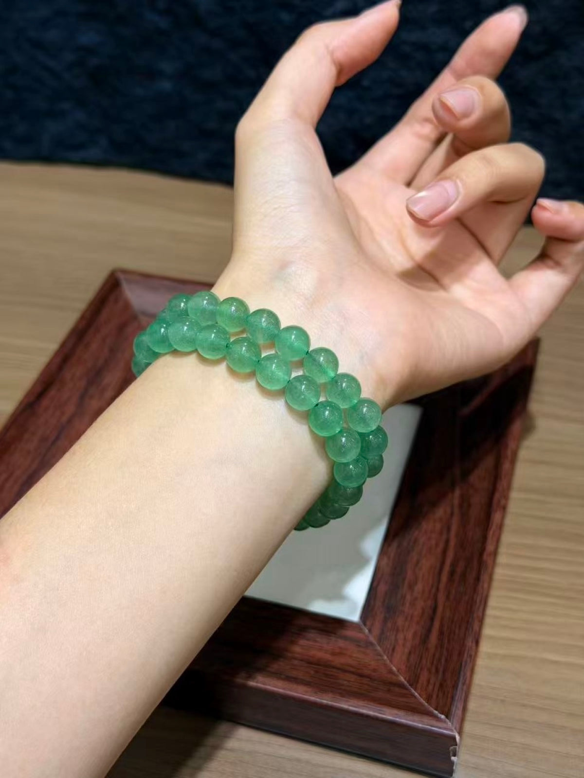 Green strawberry quartz bracelets worn stacked on wrist
