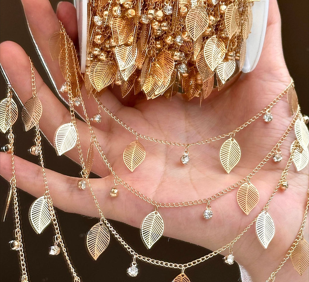 Hand holding white container with gold leaf rhinestone fringe chains