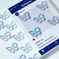 Iridescent butterfly-shaped glass beads on a white surface next to an Instagram post mockup