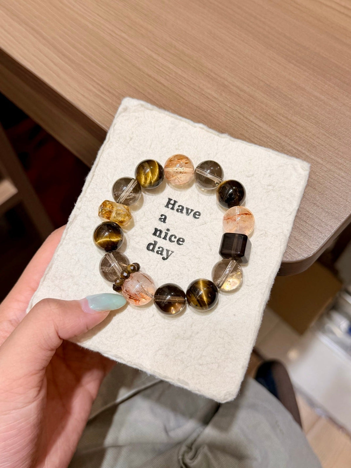 Brown tiger's eye and smoky quartz beaded bracelet on a 'Have a nice day' card