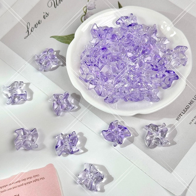 Clear and light purple translucent 20mm carved glass windmill beads on a white surface with a white dish