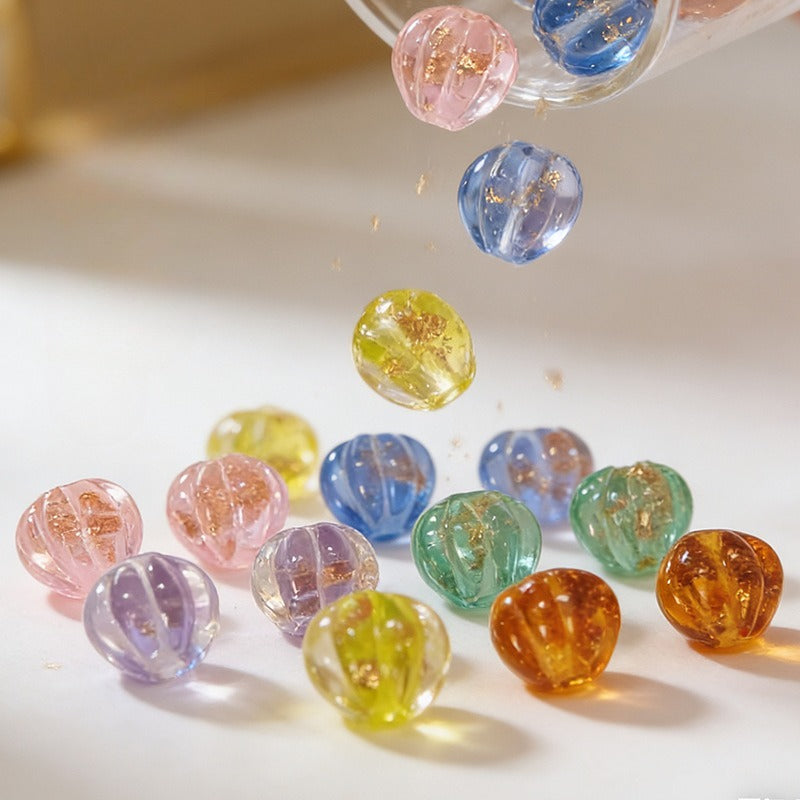 Colorful translucent gold-sand lantern glass beads on a white surface