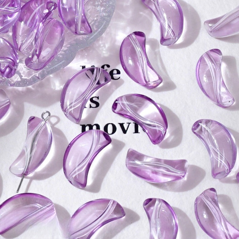 Light purple translucent crescent glass beads on white with 'life movie' text and a dish