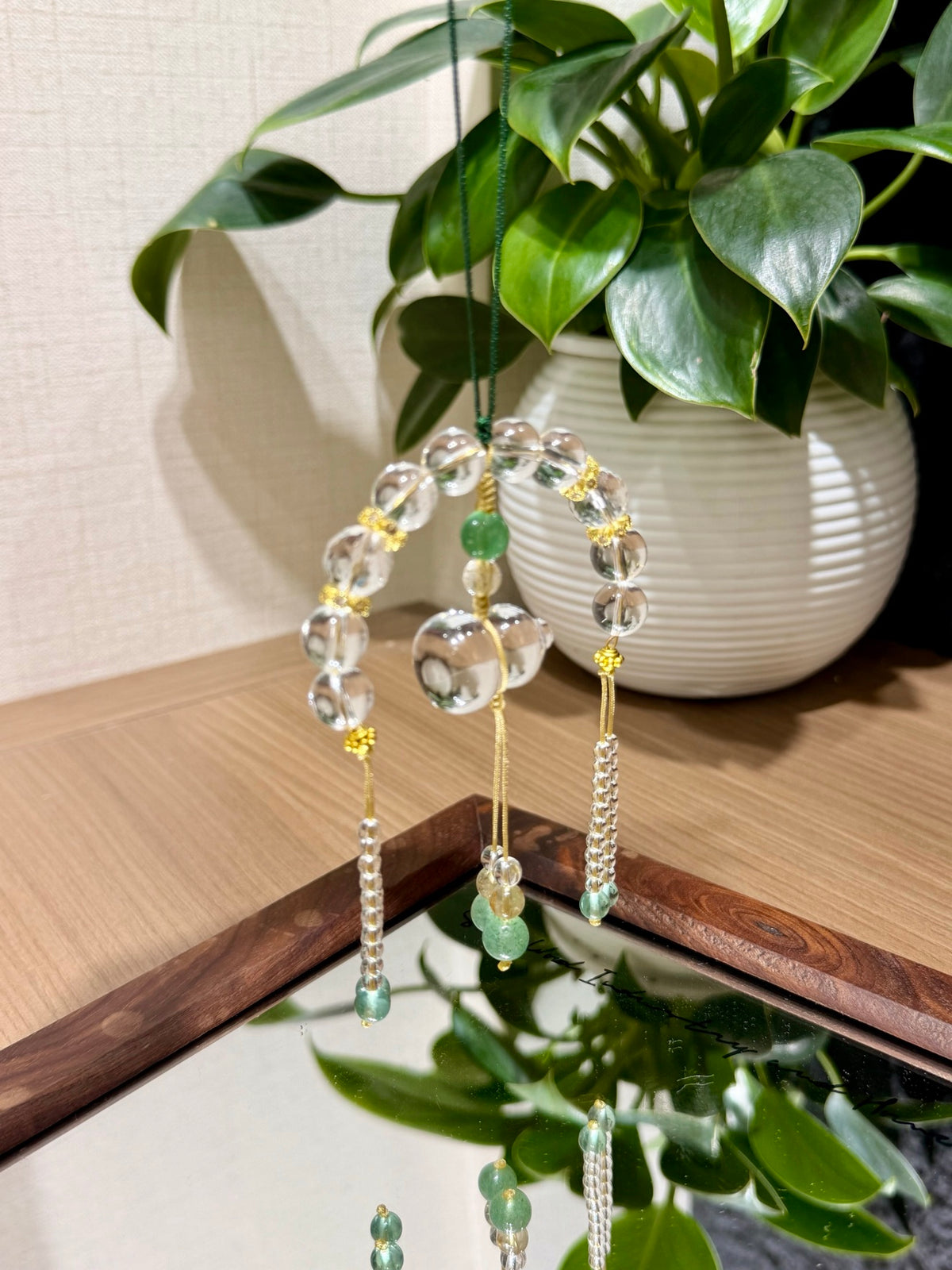 White crystal gourd car charm hanging by plant