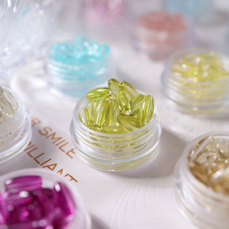 Small clear jars filled with colorful 4x9mm glazed glass long rice beads