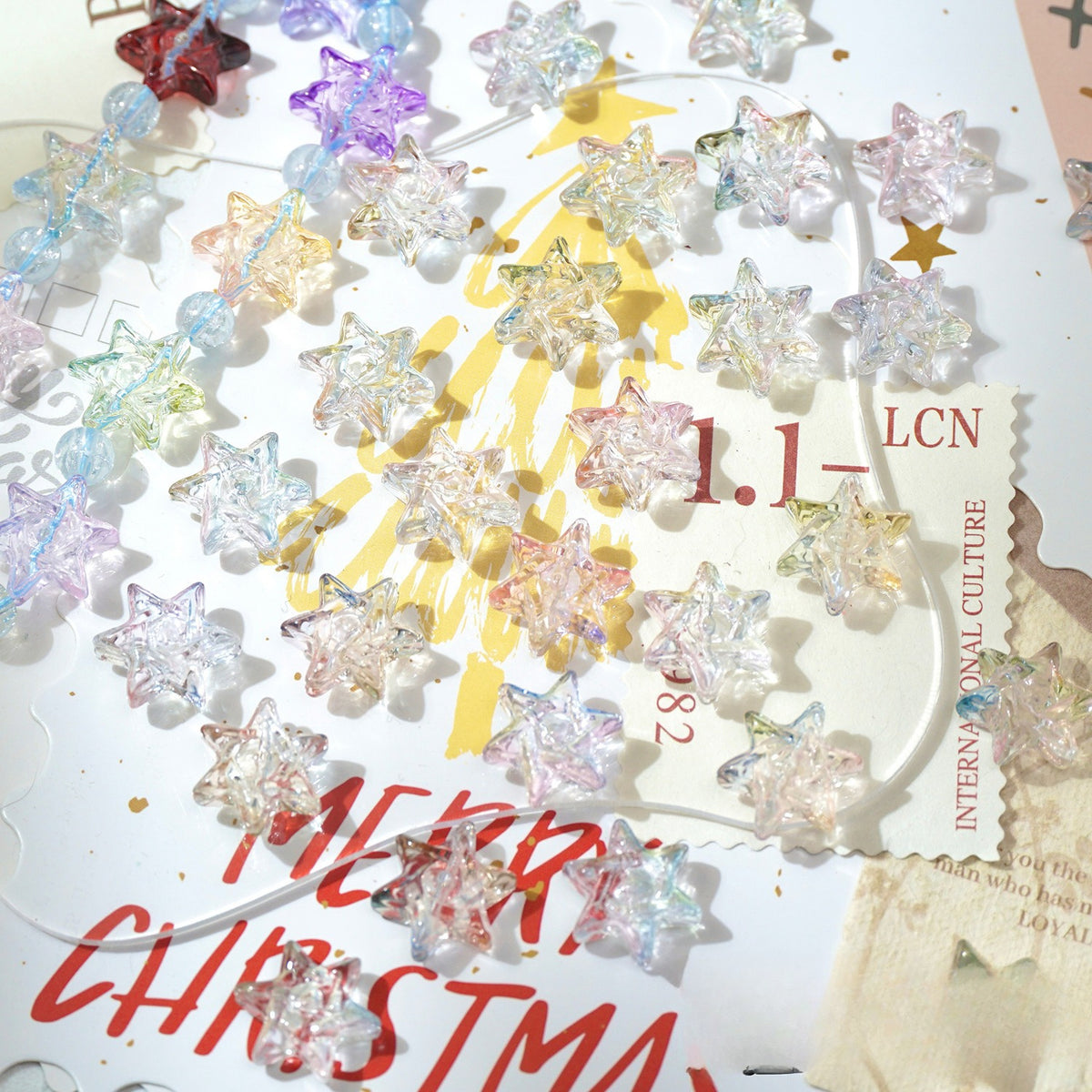 Clear faceted star-shaped glass beads scattered on a white Christmas-themed background