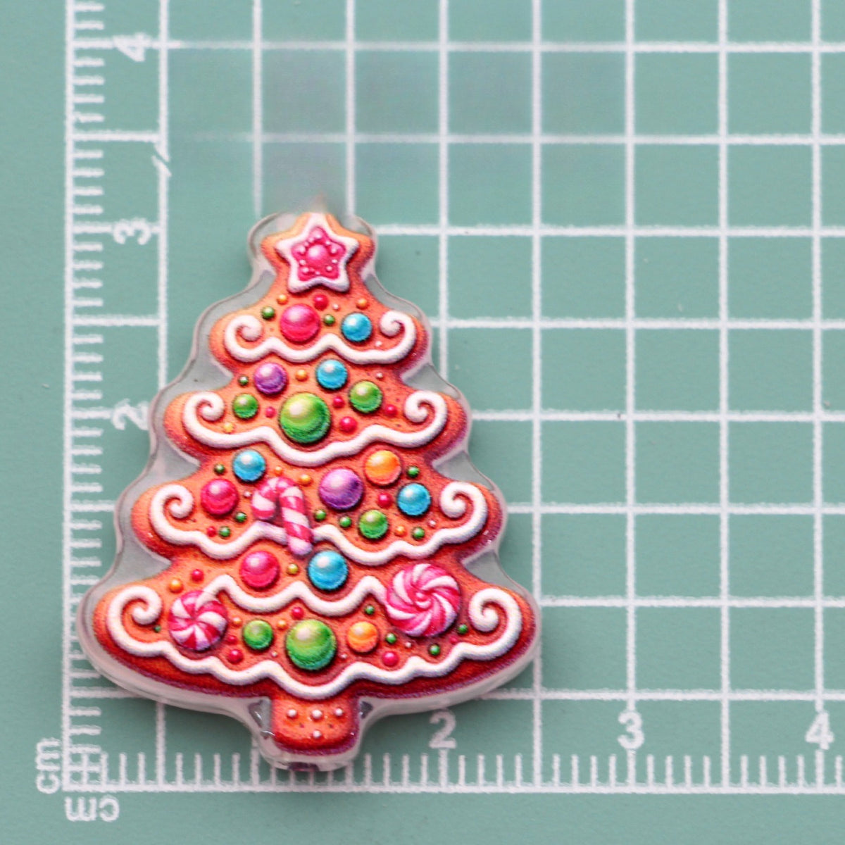 Gingerbread Christmas tree acrylic charm with colorful candy dots and white icing on green mat