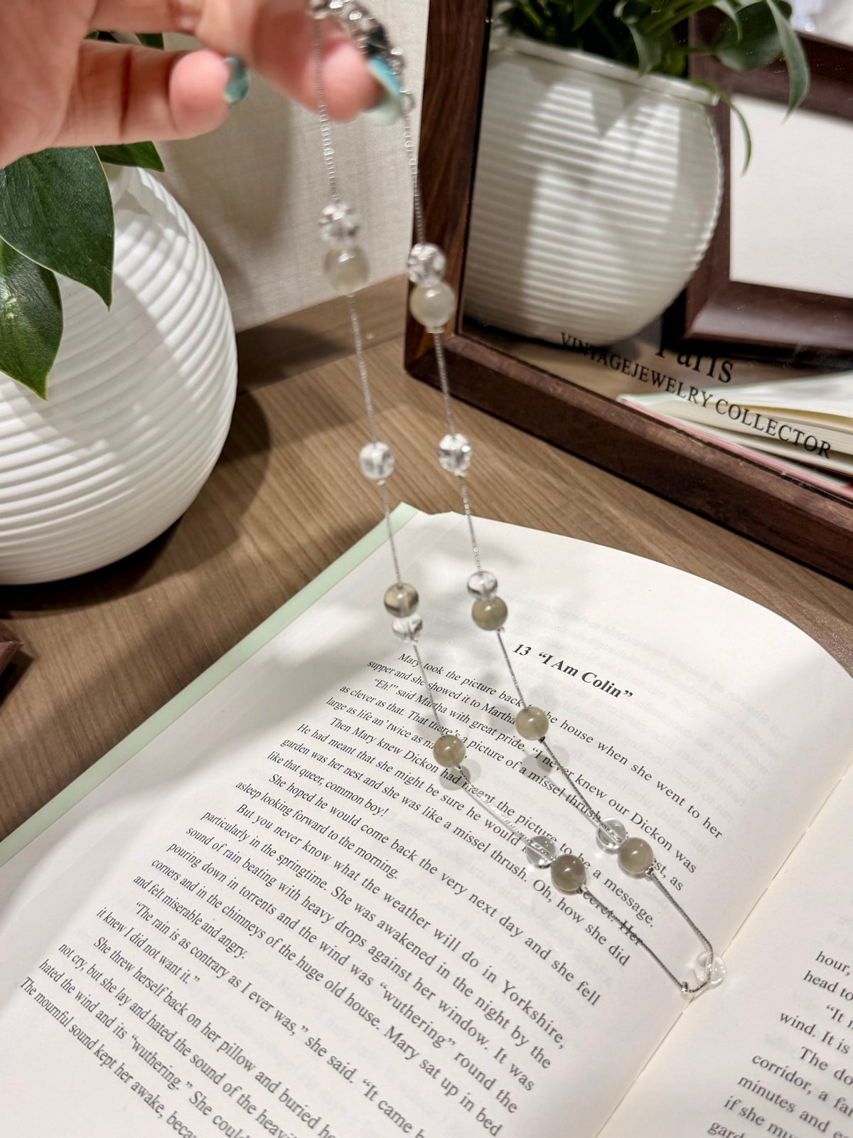 Misty moon necklace laid on open book showing beads and clasp