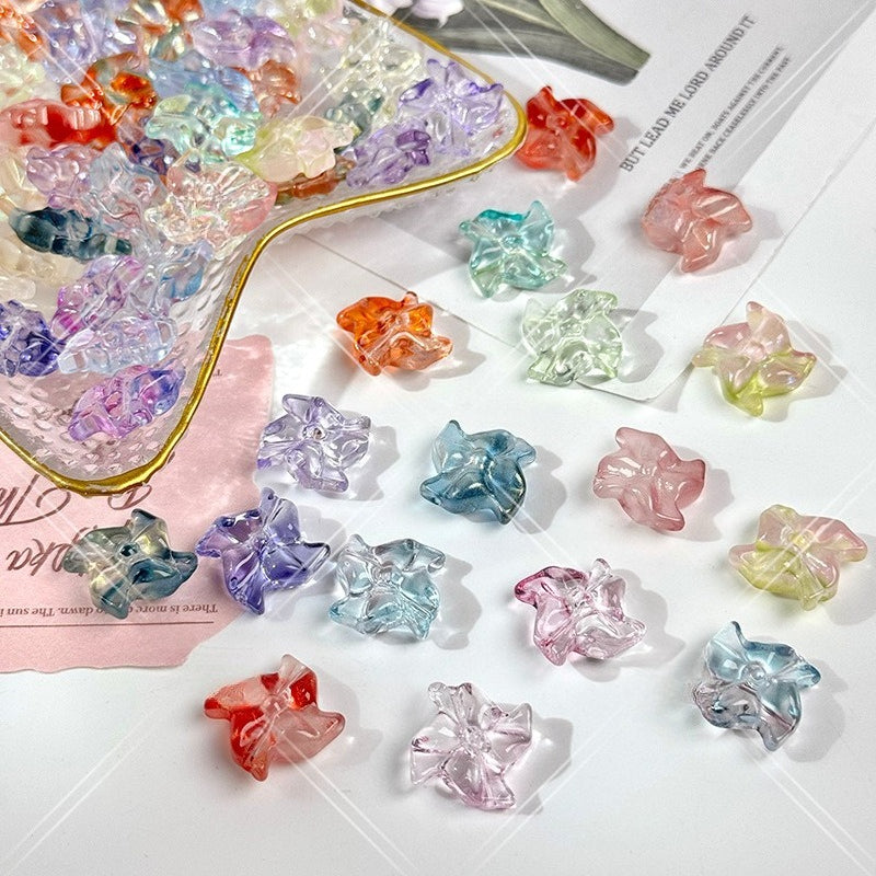 Collection of translucent pastel and bright 20mm carved glass windmill beads, some in a clear container with gold rim