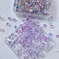 Clear storage containers of small iridescent pastel rectangular glass beads
