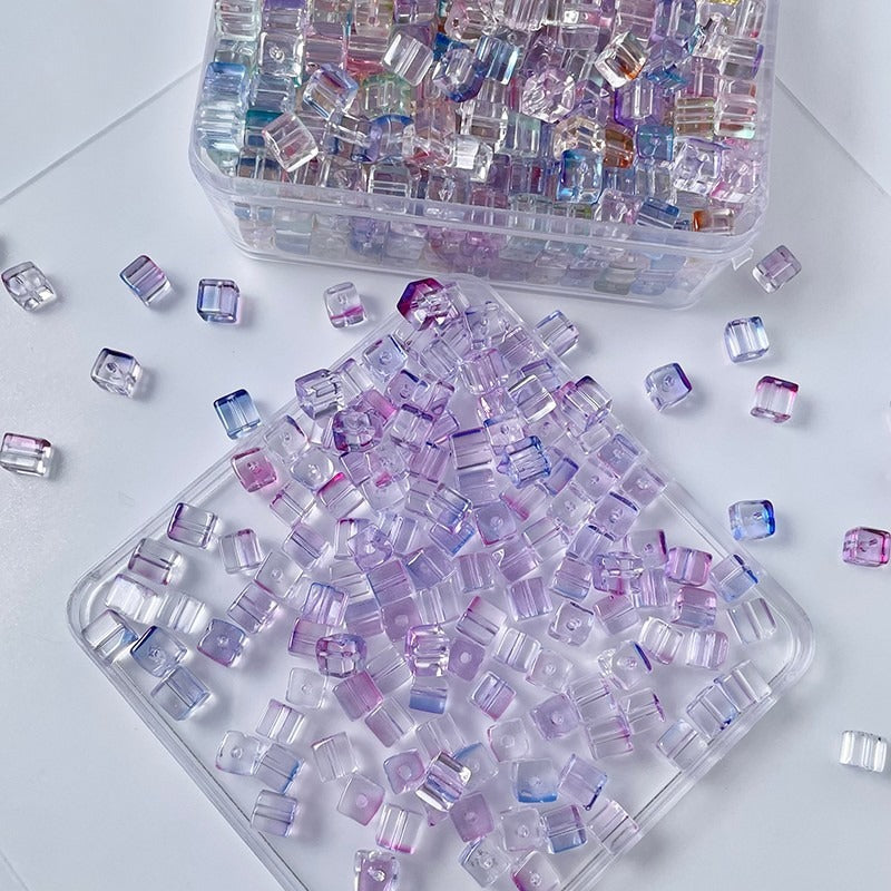 Clear storage containers of small iridescent pastel rectangular glass beads