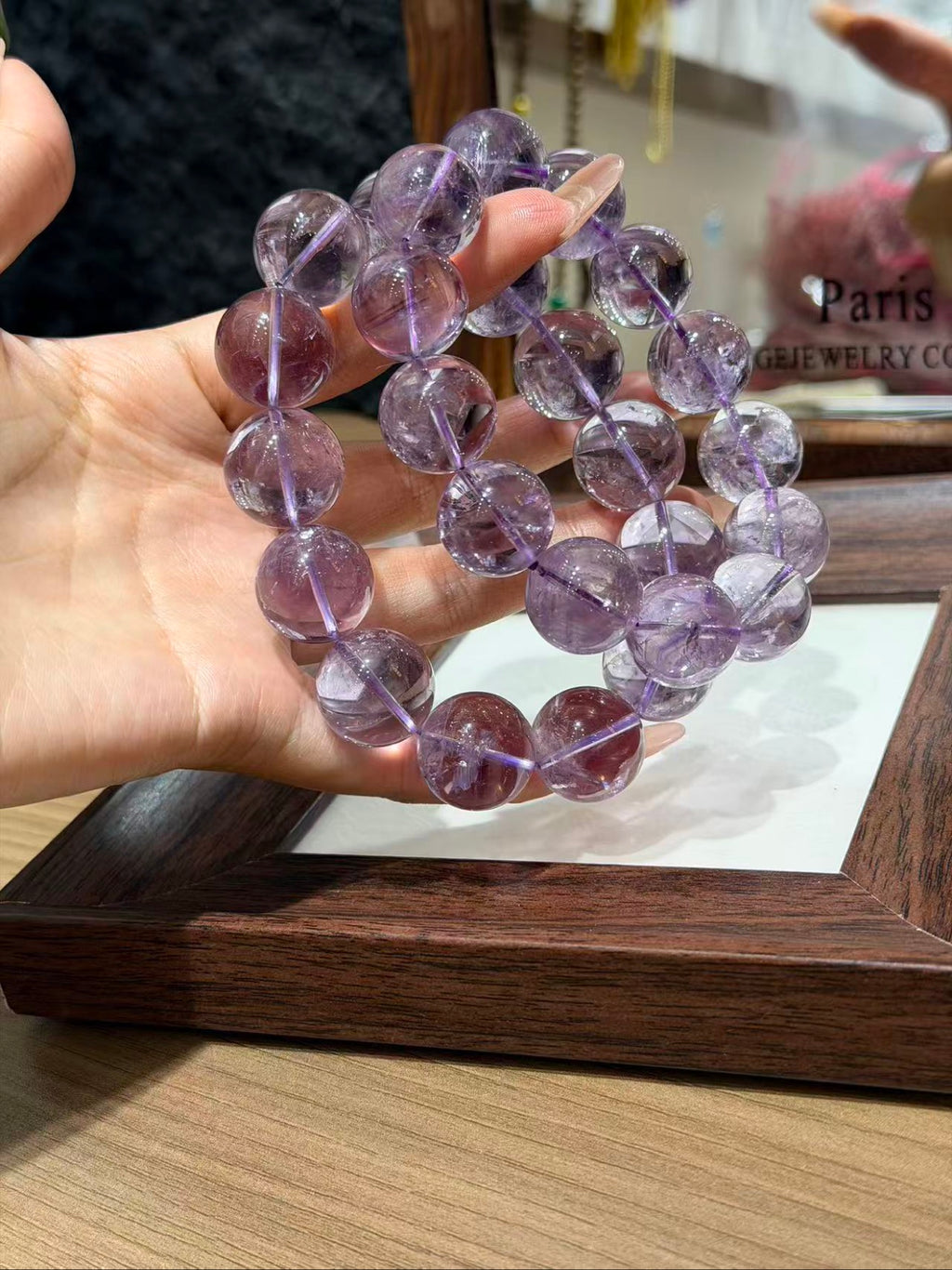 Hand holding Bolivian amethyst bracelet strands