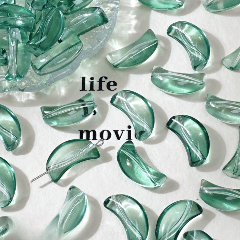 Green translucent crescent glass beads on white with 'life' text and a glass dish