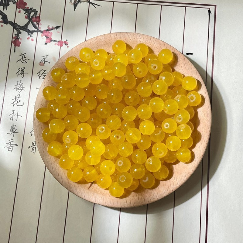 Translucent yellow round beads on a wooden plate with calligraphy background