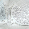White glitter barrel beads on a white tray with lace fabric and a printed card behind