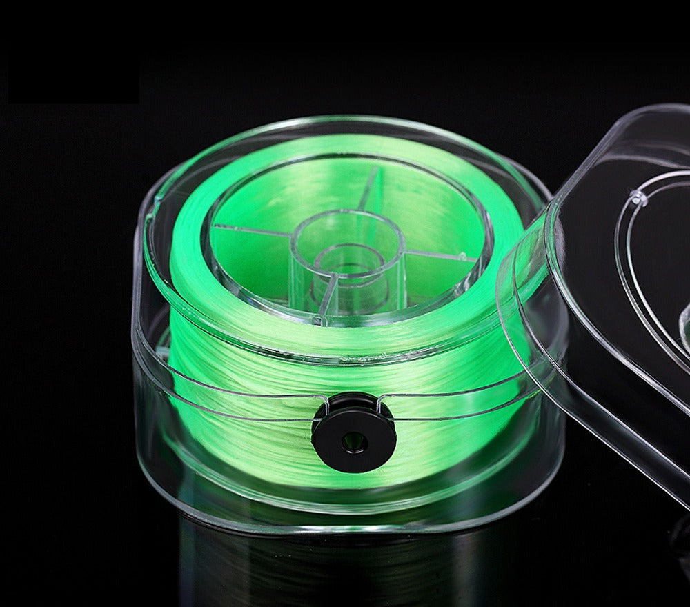 Neon green elastic beading cord on a spool in a clear plastic case with lid partially open, on black background