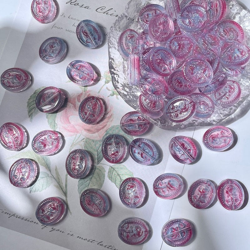 Round engraved glass rose beads with pink and purple floral designs on white