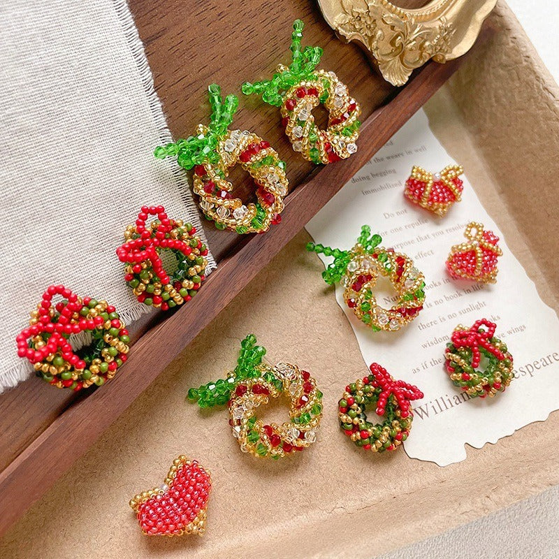 Beaded Christmas wreath and heart charms in red, green, and gold seed beads on a wooden tray