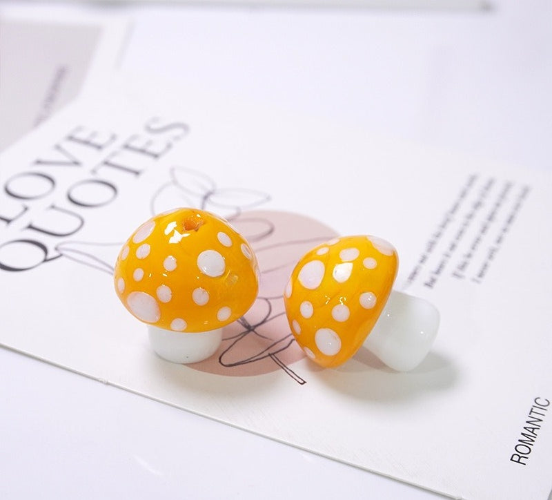 Two yellow-orange glass mushroom beads with white spots on LOVE QUOTES card