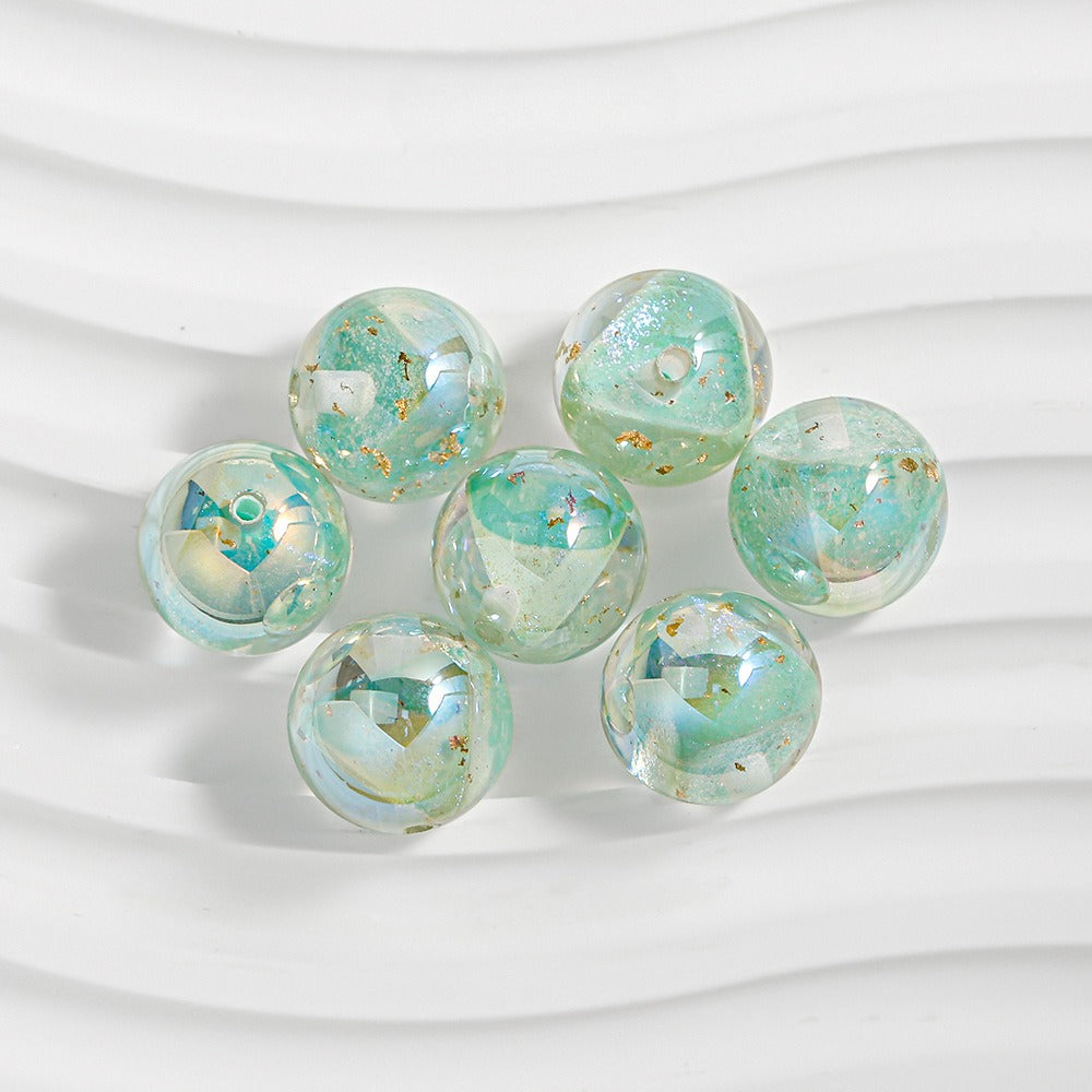 Seven mint green resin beads with iridescent blue sheen and gold foil