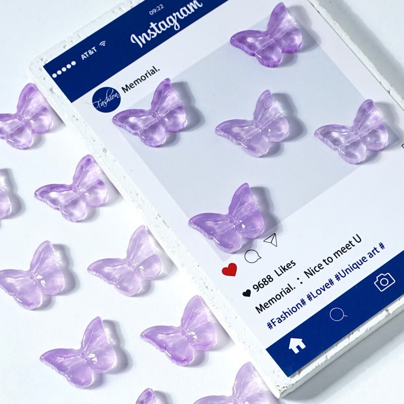 Package of translucent lavender butterfly-shaped glass beads on a white surface