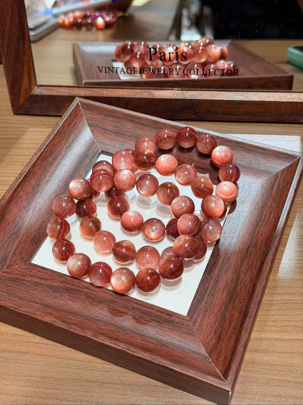 Pink lepidolite bead bracelet in a heart shape on a dark wood tray