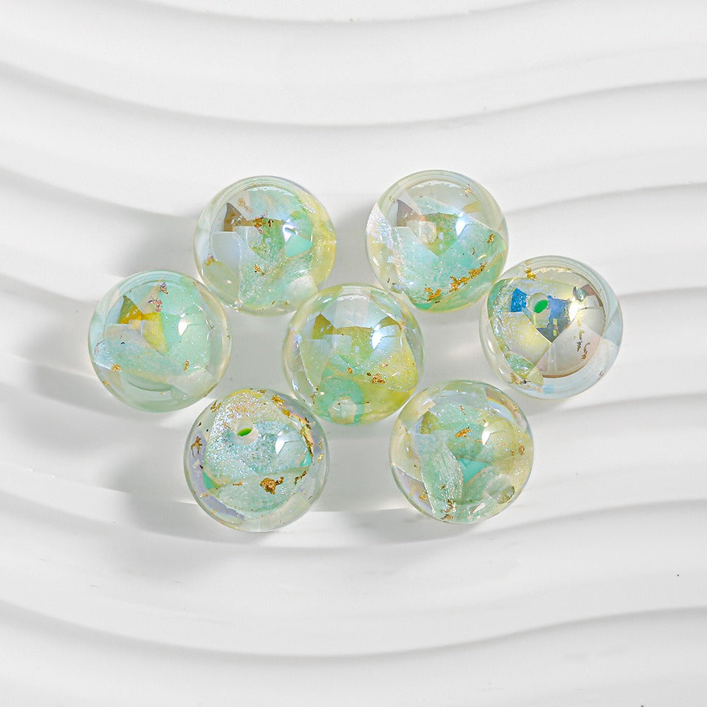 Seven iridescent resin beads with gold foil flakes in loose circle
