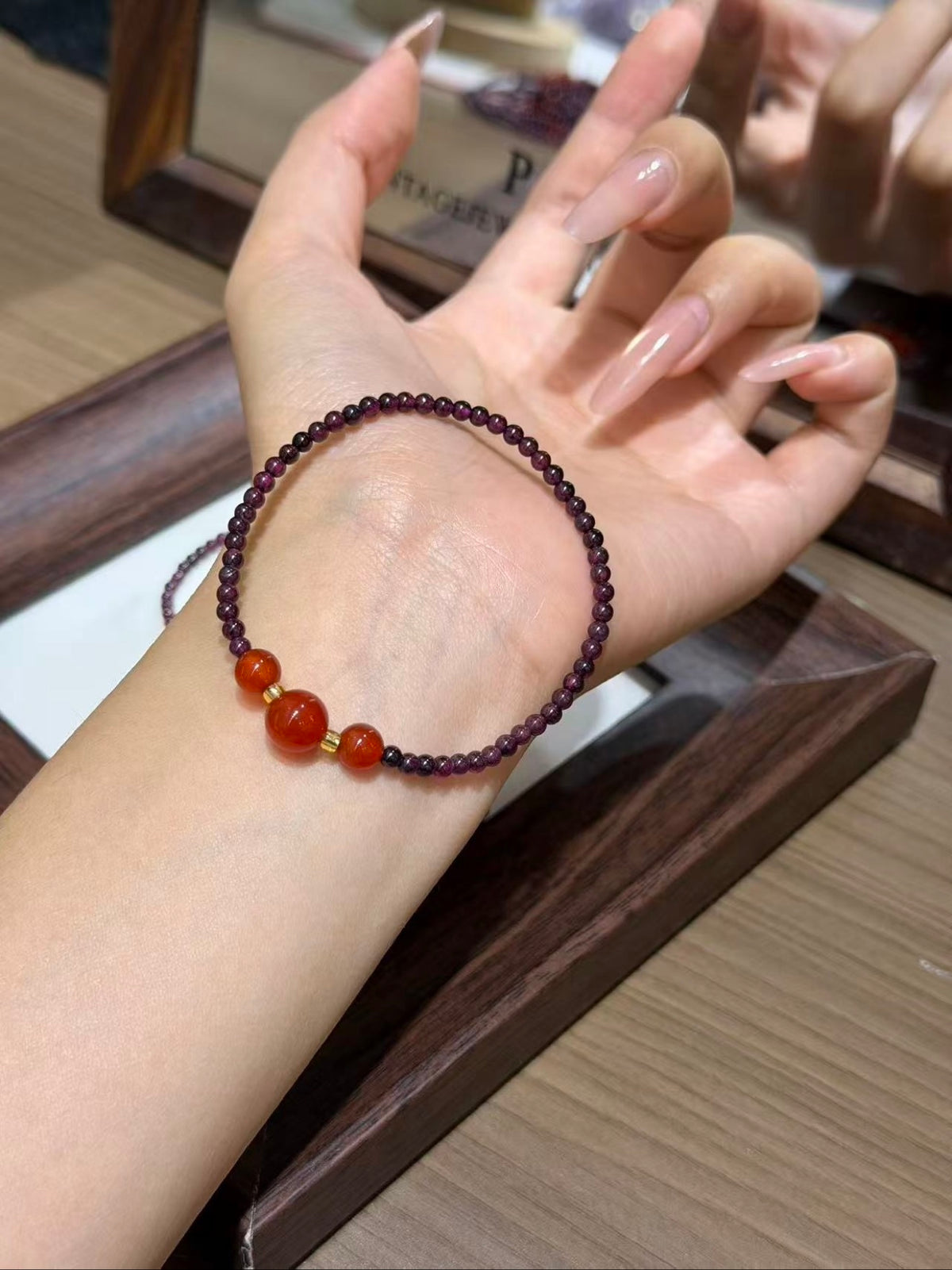 Purple garnet and carnelian bracelet set worn on a wrist
