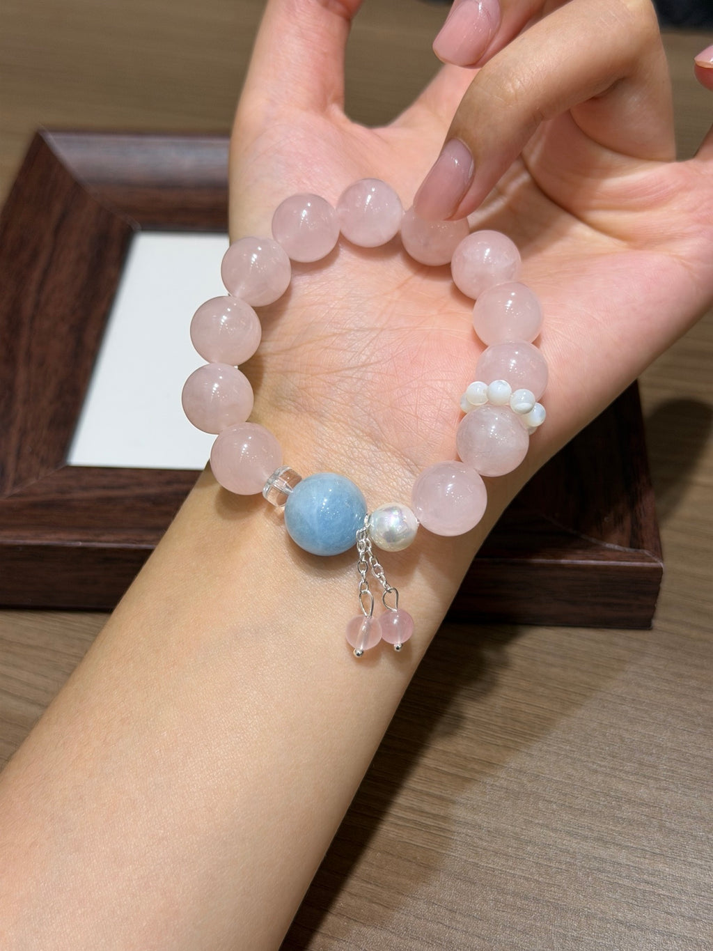 Peach mist pink quartz bracelet with aquamarine worn on wrist