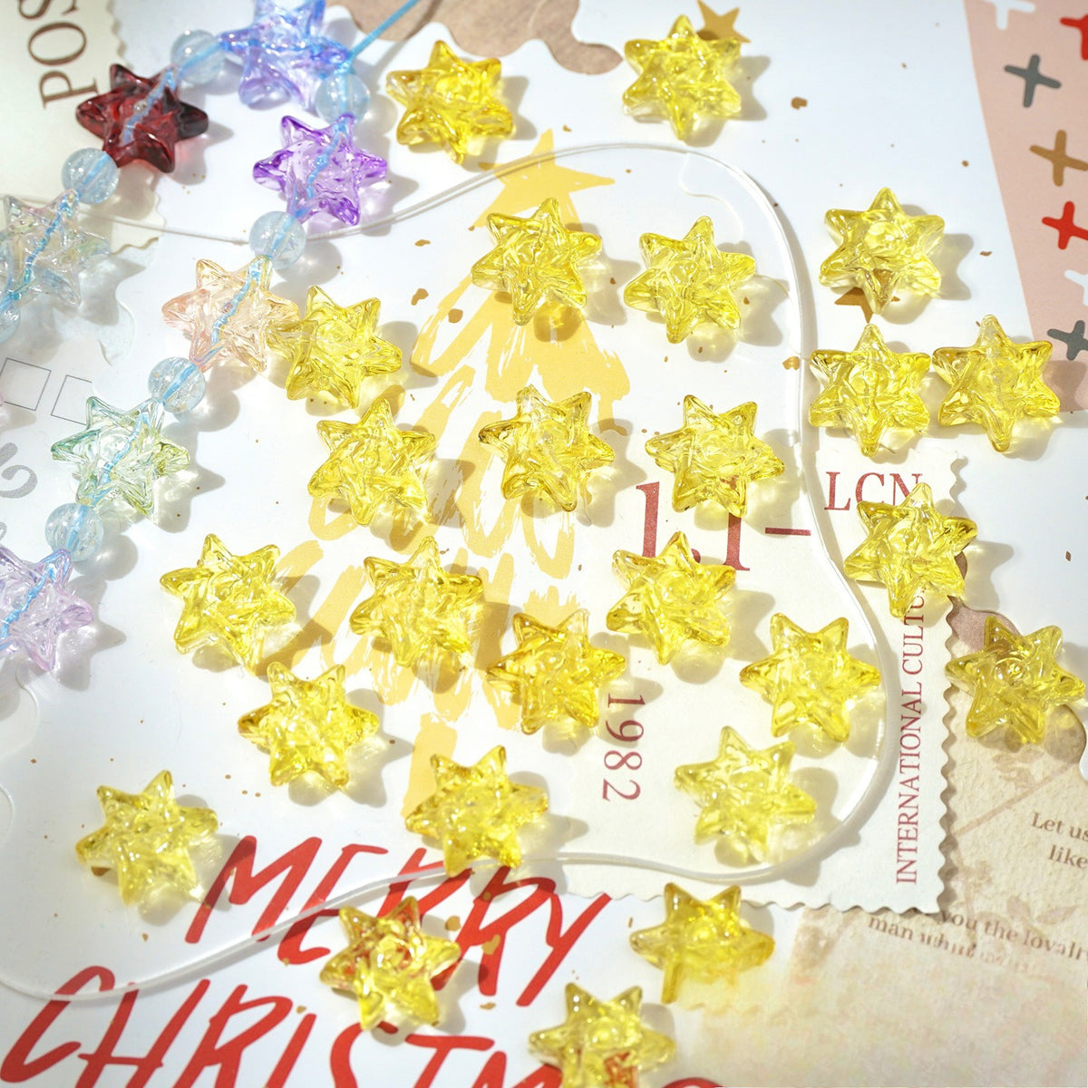 Yellow translucent star-shaped glass beads scattered on a white background