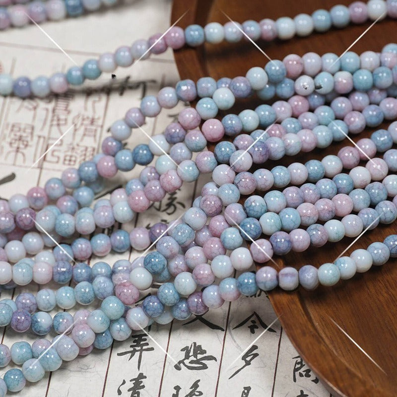 Multicolor pastel round porcelain beads in blue, pink, lavender on wooden tray