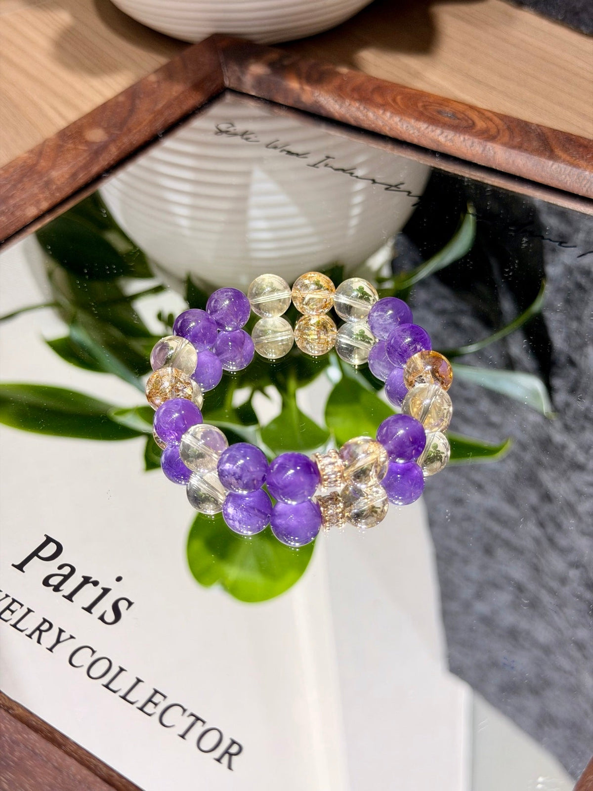 Amethyst and citrine beaded bracelet on a mirror over a Paris Jewelry Collector card