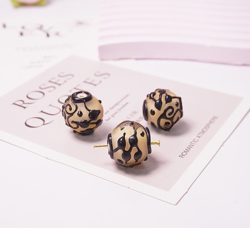 Three round dangle earrings with a beige and black leopard print pattern and gold-tone posts, displayed on a decorative card.