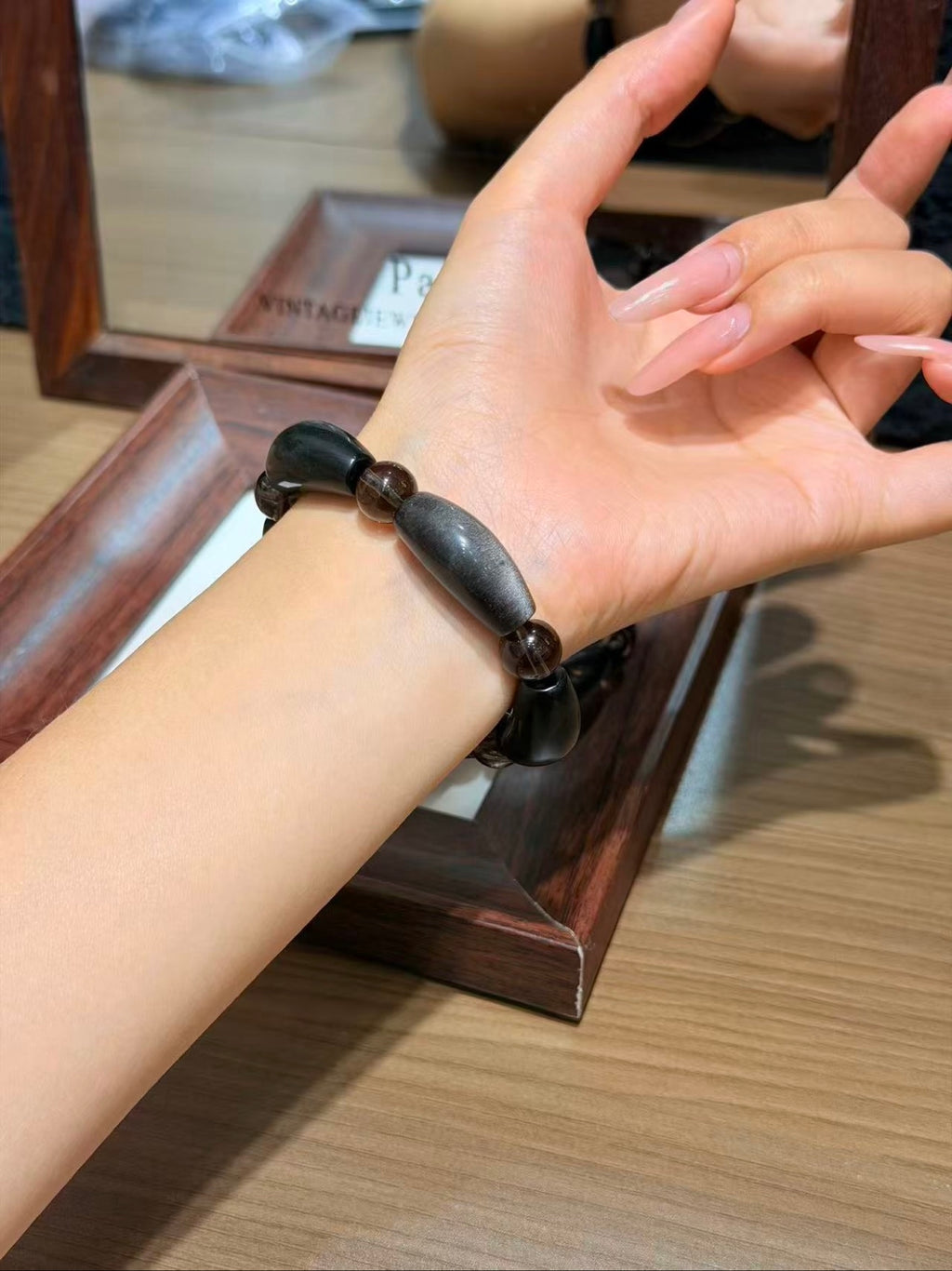 Silver obsidian petal-tube bracelet worn on wrist