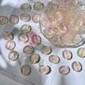 Oval engraved glass rose beads with vintage designs, some piled in a glass bowl