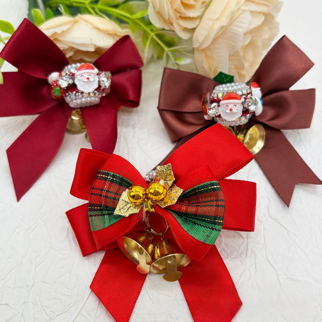 Three Christmas bow focal beads with Santa charms and gold bells: red satin, brown satin, and red plaid bows.