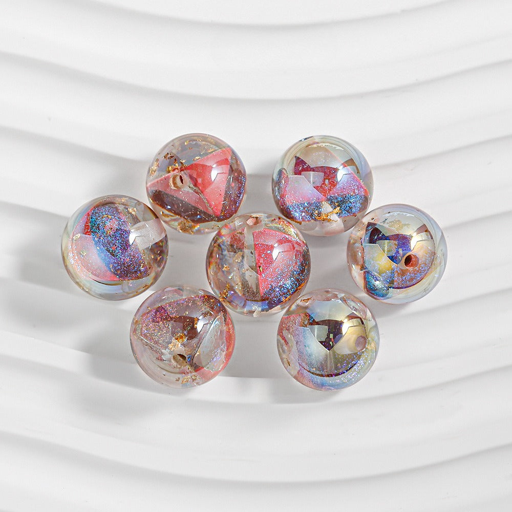 Six clear resin beads with pink, blue and gold glitter