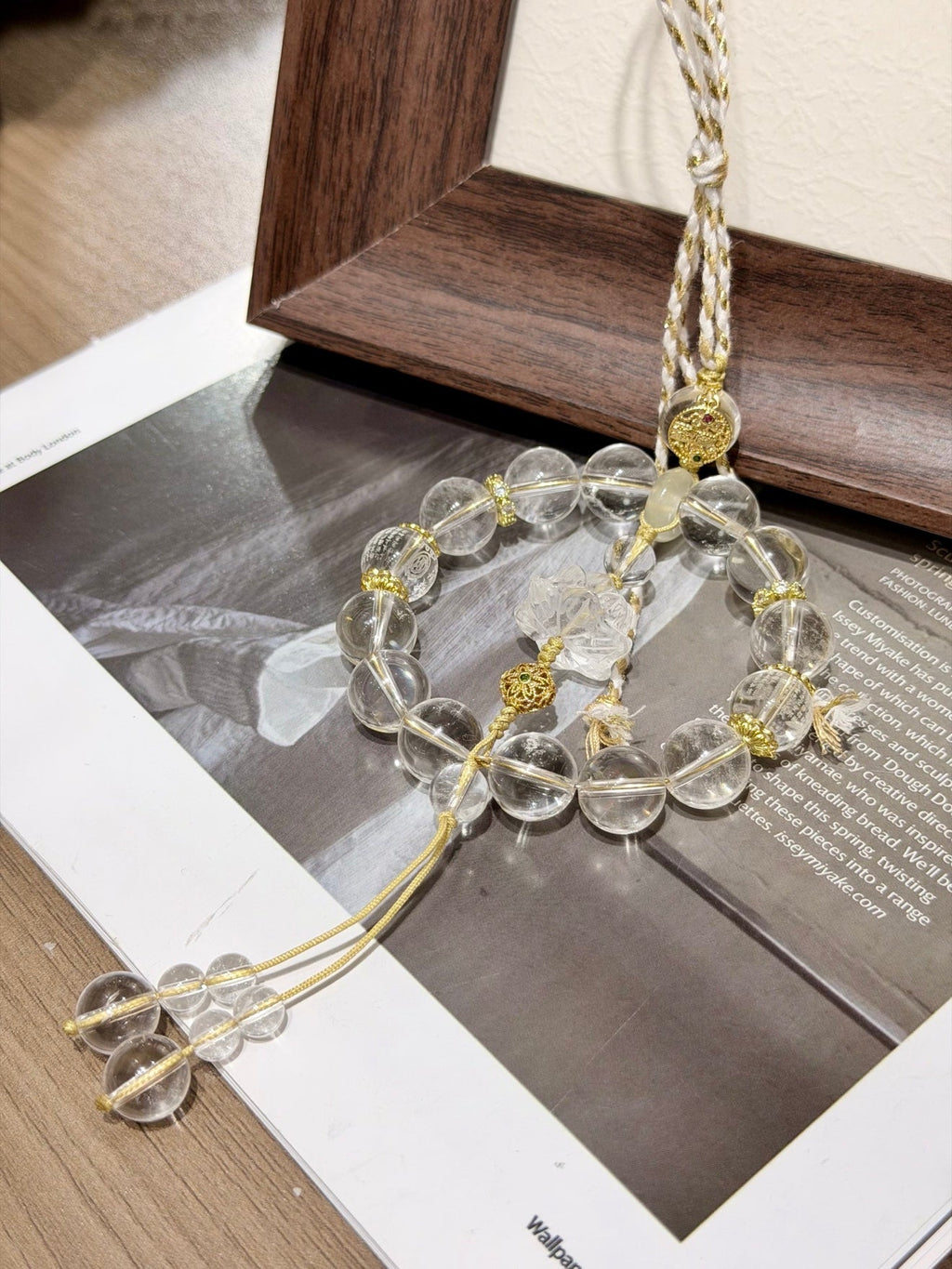 Circular clear quartz beaded car charm with carved lotus center, citrine peace buckle and champagne-gold cord