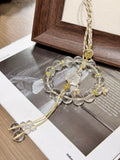 Circular clear quartz beaded car charm with carved lotus center, citrine peace buckle and champagne-gold cord