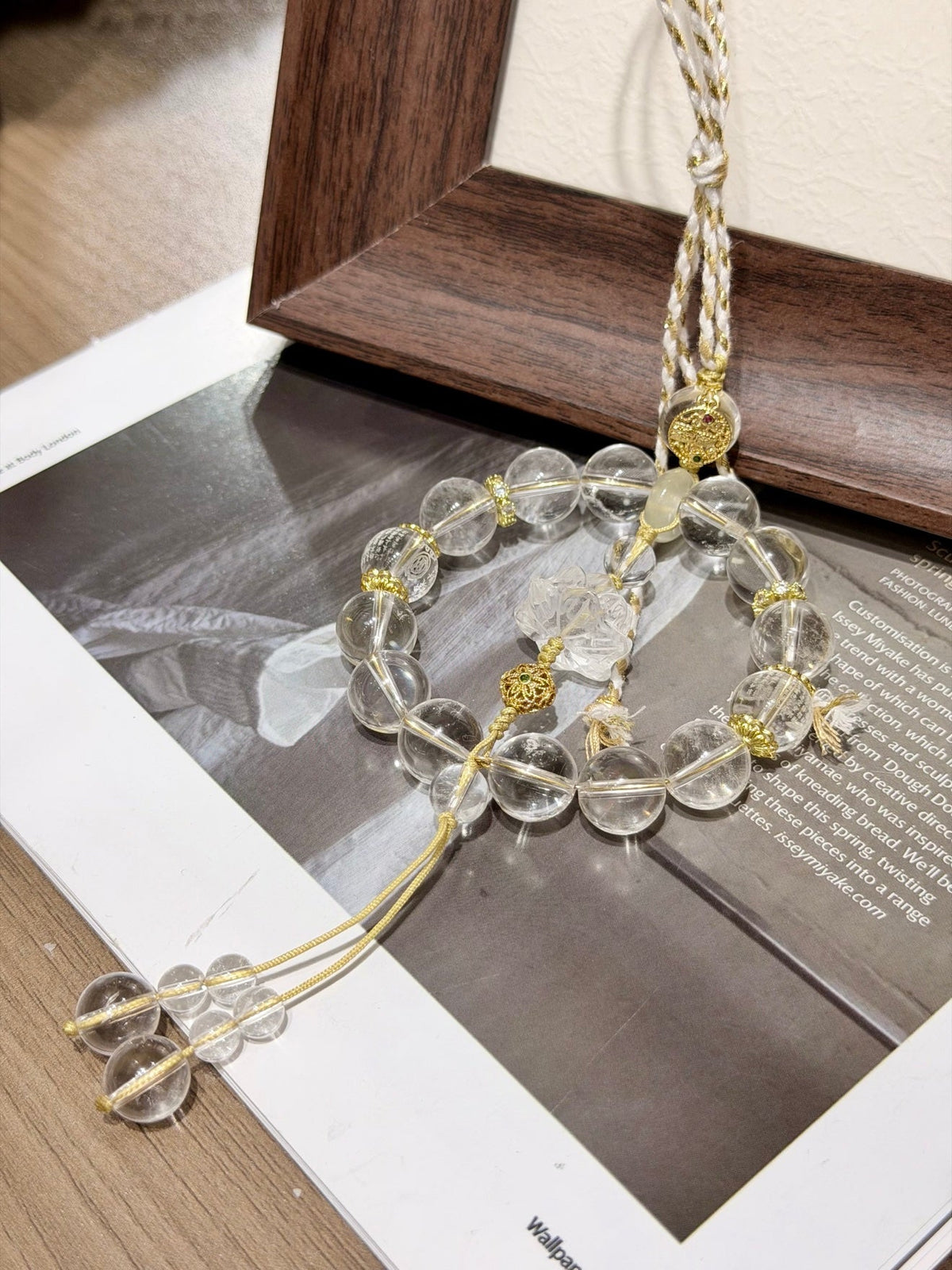 Circular clear quartz beaded car charm with carved lotus center, citrine peace buckle and champagne-gold cord